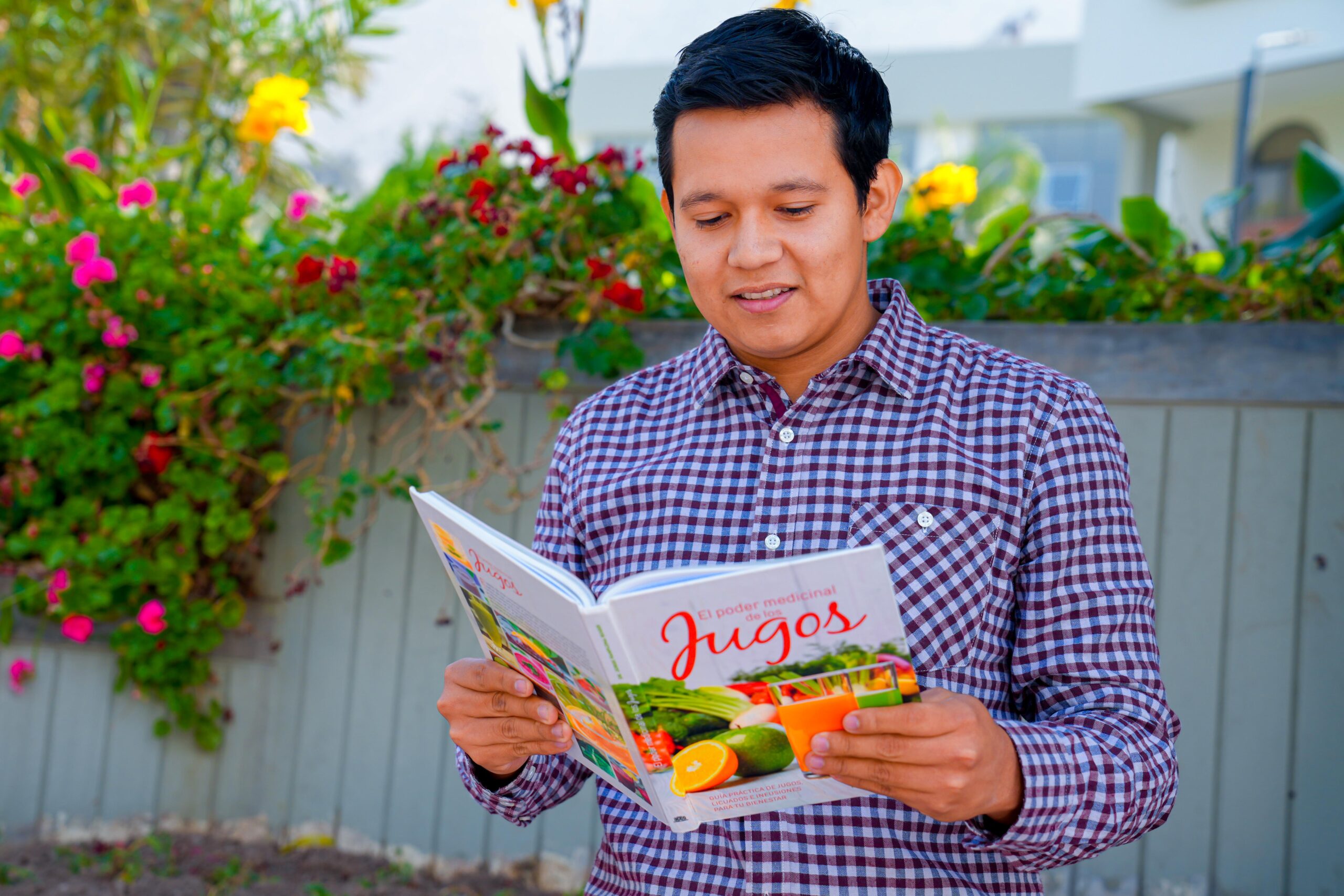 Joven leyendo el libro El poder medicinal de los jugos, promoviendo el bienestar y salud familiar a través de la alimentación.